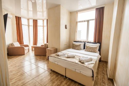 a bedroom with a bed in a room with windows at Batumi Inn Hotel in Batumi