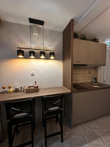 27 Urban Stay في Neochorópoulon: مطبخ مع كونتر مع كرسيين ومغسلة