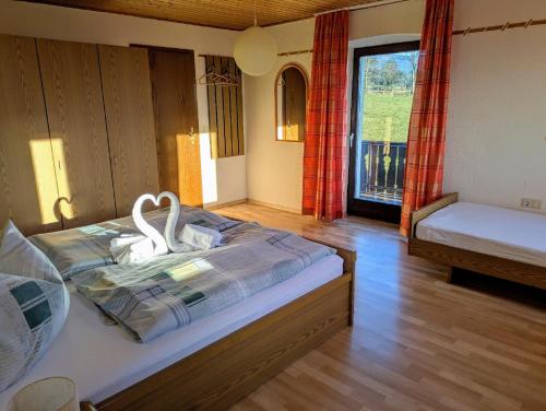 a bedroom with a bed with two swans on it at Ferienwohnungen am Arber - Haus Osser - in Lohberg