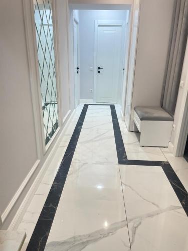 a hallway with a black and white tile floor at Apartament modern in Căuşeni