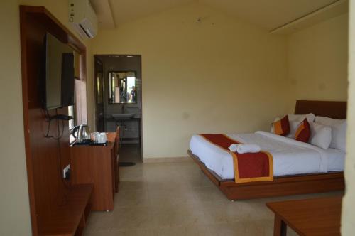 a hotel room with a bed and a television at S K Pushkar Resort in Pushkar