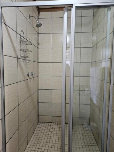 ein Bad mit einer Dusche und weißen Fliesen in der Unterkunft 15 Elizabeth Eybers str in Bloemfontein