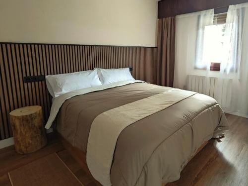 a large bed in a bedroom with a window at Apartamento Cumbre Loba in La Pinilla