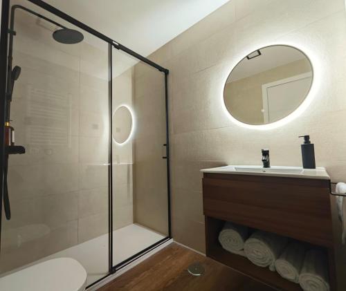 a bathroom with a shower and a sink and a mirror at Apartamento Cumbre Loba in La Pinilla