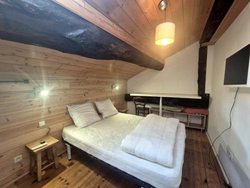 una camera da letto con un letto in una stanza di legno di Appartement 4pers - Hyper centre Bourg St Maurice a Bourg-Saint-Maurice