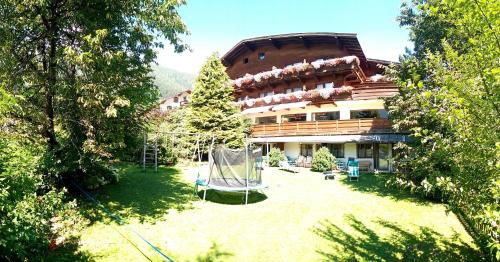 a large building with a playground in front of it at Hotel Rogen in Neustift im Stubaital