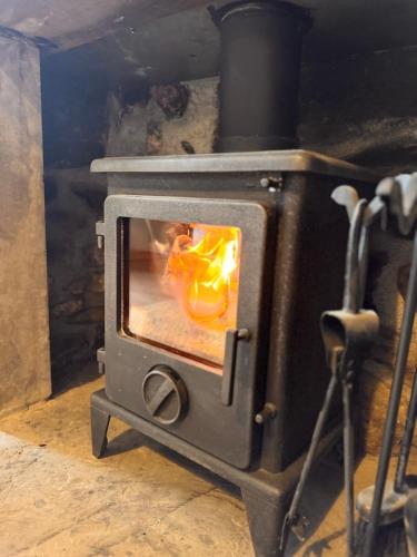 einen Herd mit einem Feuer darin in der Unterkunft La Casa De Campo - Dog Friendly Cottage in Long Preston