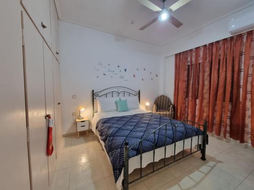 a bedroom with a bed with a blue comforter at Isthmus Filoxenia in Isthmia