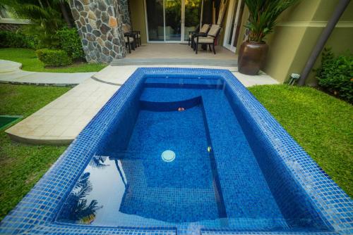 a blue swimming pool in the yard of a house at Vista Bahia 3D - 3bdr 3bath plunge pool in La Mona