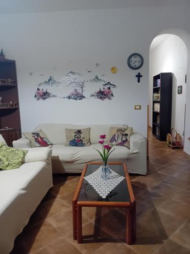 a living room with two white couches and a table at Casa Waida in Marinella di Selinunte