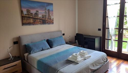 アッサーゴにあるApartment Vittoria Assago Forumのタオルが敷かれたベッドのある寝室