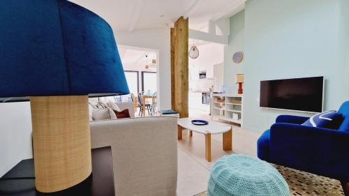 een woonkamer met een bank en een tafel bij Le Corail, maison cosy avec terrasse in Les Sables-dʼOlonne