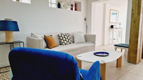 een woonkamer met een bank en een tafel bij Le Corail, maison cosy avec terrasse in Les Sables-dʼOlonne