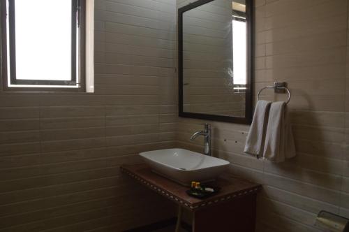 a bathroom with a sink and a mirror at S K Pushkar Resort in Pushkar