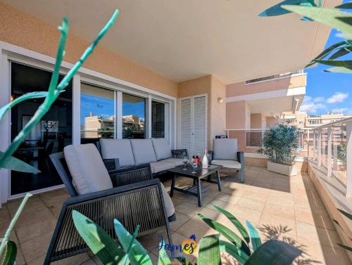 un patio con divano e sedie sul balcone. di Tropical 3BR Oasis with Pool EB17 a Los Dolses