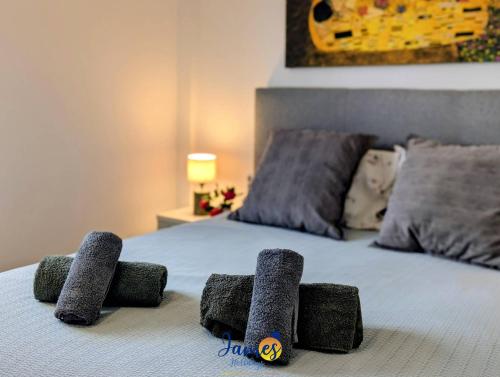 un letto con sopra quattro asciugamani grigi di Tropical 3BR Oasis with Pool EB17 a Los Dolses