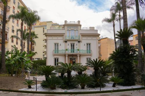 a building with palm trees in front of it at Villa Magnolia in Castellammare di Stabia