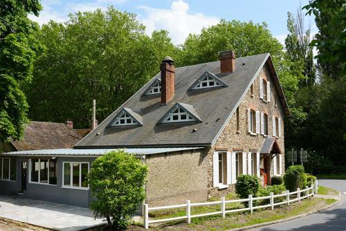 een huis met een gambrel dak op een straat bij L'Auberge 91530 in Le Val-Saint-Germain