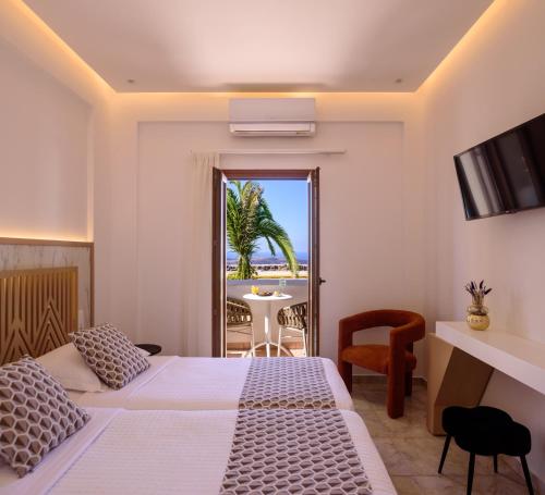 a bedroom with a bed and a view of the ocean at Astir Thira Hotel in Fira