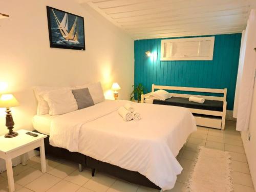 a bedroom with a large white bed and a window at Pousada dos Pássaros Geribá in Búzios