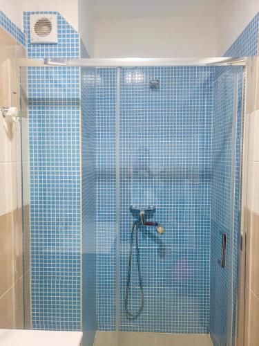 ein Badezimmer mit Dusche und blauen Fliesen in der Unterkunft Castelinho Sal Lodge in Espargos