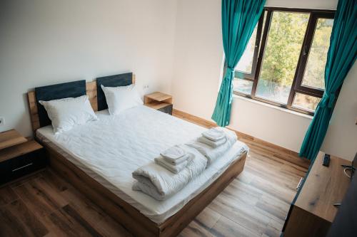 Un dormitorio con una cama con toallas. en Къща за гости Бели Осъм, en Beli Osŭm