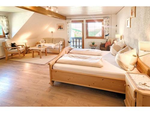 a bedroom with a large bed and a living room at Kirchlehof in Oberried
