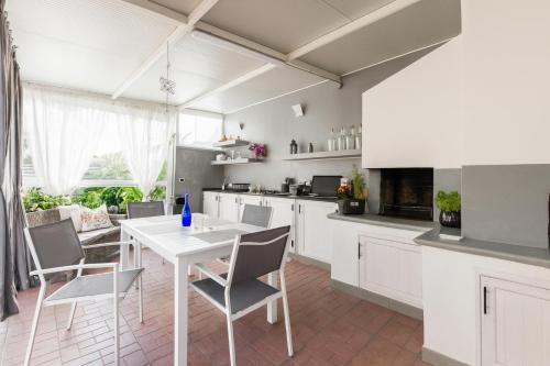 eine Küche mit weißen Schränken sowie einem weißen Tisch und Stühlen in der Unterkunft La Casa del Viaggiatore in Milazzo