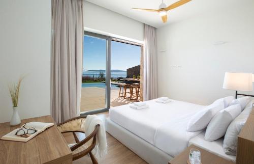 a bedroom with a bed and a view of the ocean at Amber by the sea in Évyiros