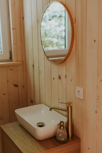 a bathroom with a white sink and a mirror at Tiny house nad potokiem in Sidzina