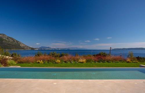 a swimming pool with a view of the water at Amber by the sea in Évyiros