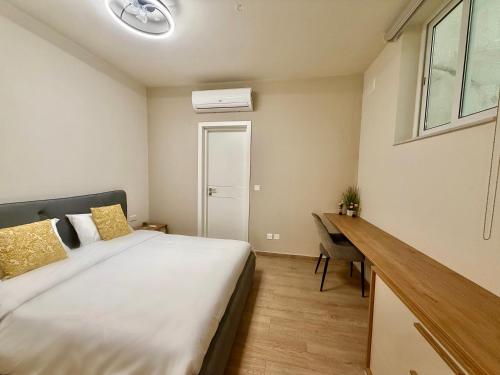 a bedroom with a bed and a desk and a window at The Rue in Il-Gżira