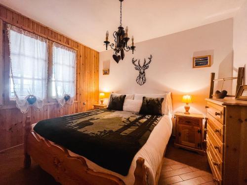 um quarto com uma cama grande e um lustre em Rifugio delle Cascate - Poluc Apartments Bilocale em Champoluc