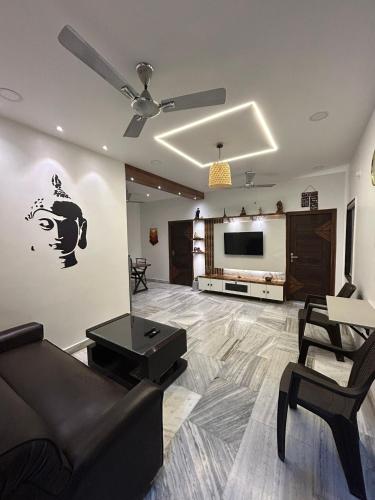 een woonkamer met een bank en een flatscreen-tv bij Guhan HomeStay- 2BHK Serviced Apartments - Full Furnished & Full Kitchen, WiFi & Balcony in Hyderabad