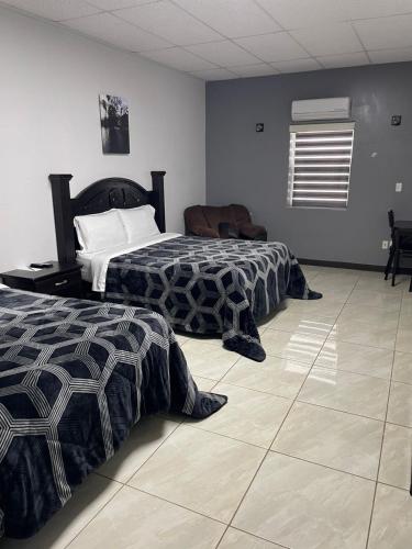 two beds sitting in a room with at Hotel Plaza Berrendo in Campo Menohita 307
