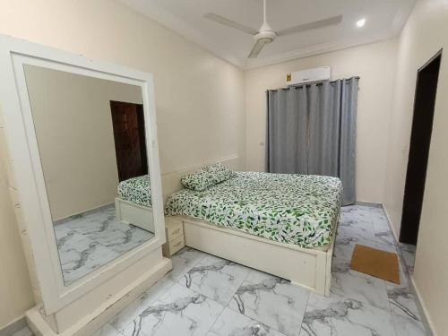 a bedroom with a mirror and a bed in it at Premium House Kouritenga ISPP in Ouagadougou