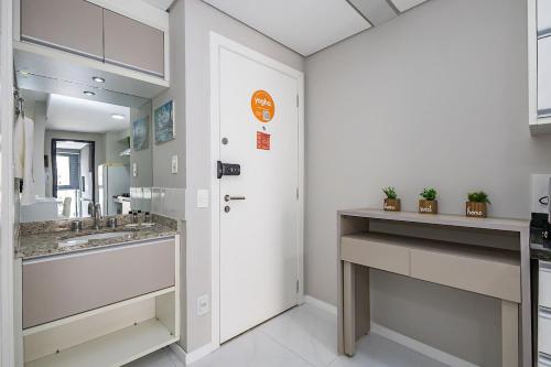 a bathroom with two sinks and a white door at Edifício Champagnat Office in Curitiba