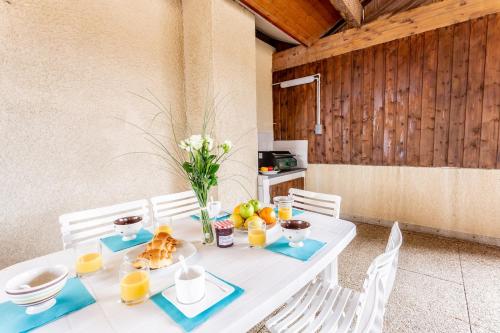 een witte tafel met eten en sinaasappels erop bij L'Echassier in Biscarrosse