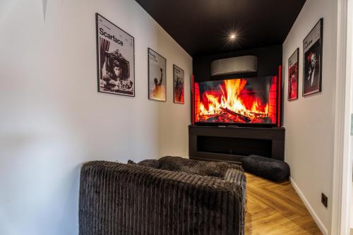 a living room with a couch and a fireplace at Saga - Cinema Room in Chagny