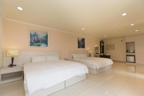 a bedroom with two beds and a kitchen at F Hotel - Sanyi in Sanyi