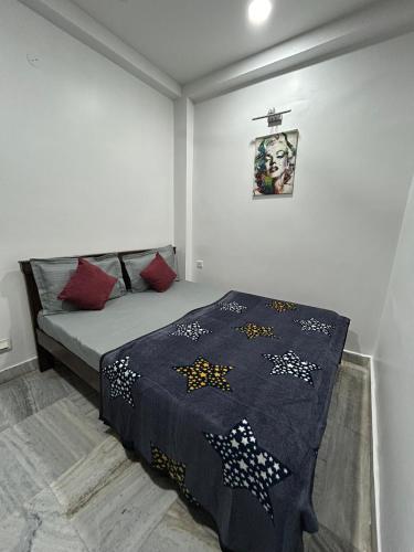 een slaapkamer met een bed met een deken erop bij Guhan HomeStay- 2BHK Serviced Apartments - Full Furnished & Full Kitchen, WiFi & Balcony in Hyderabad