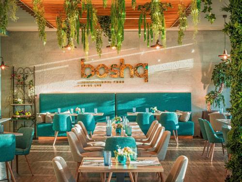 ein Esszimmer mit blauen Tischen und Stühlen in der Unterkunft Mercure Lisboa Almada in Almada