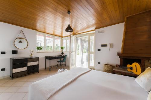 ein Schlafzimmer mit einem großen weißen Bett und einem Schreibtisch in der Unterkunft La Casa del Viaggiatore in Milazzo