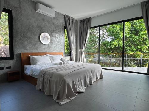 a bedroom with a large bed and a large window at DeerWood villa in Hinkong