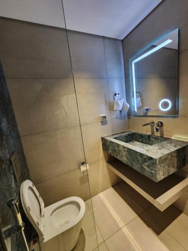 a bathroom with a toilet and a sink at Al RAHA HOTEL in Muscat