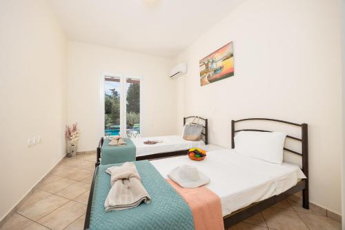 a bedroom with two beds and a table with towels at Villa Iremia in Astrakeri