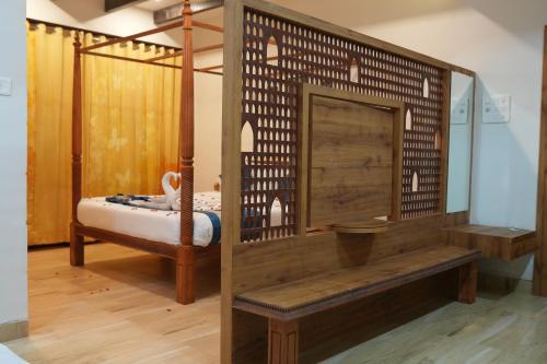 SeaFORT Beach Resort في Murūd: غرفة بسرير ومقعد خشبي