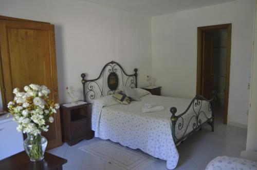 - une chambre avec un lit et un vase de fleurs dans l'établissement Agriturismo Millefiori, à Levanto