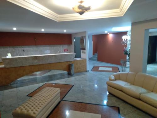a lobby with a couch and a table at Hotel Santa Fé in Ponta Grossa