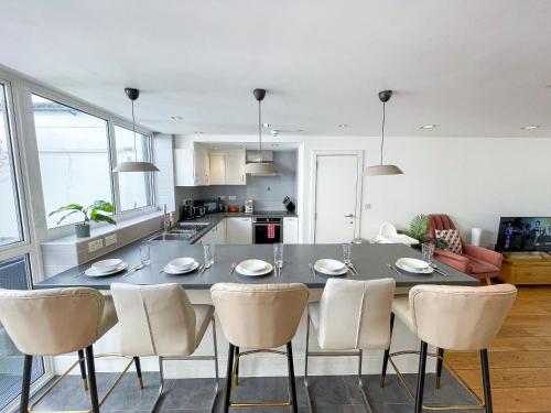 a kitchen and dining room with a table and chairs at Modern 3-Bedroom flat in Holloway with Private Patio near Islington, Caledonian Road, Emirates Stadium by Staylio Ltd in London